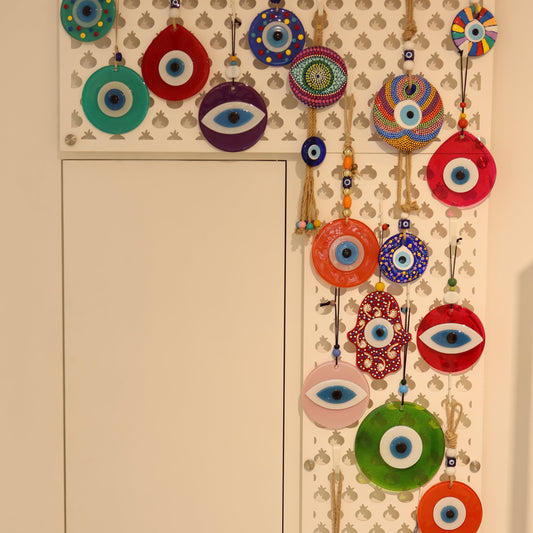 Decorative wall art with colorful eye designs on a beige background