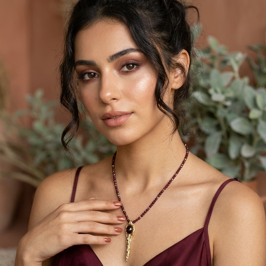 Woman wearing a necklace with a blurred natural background