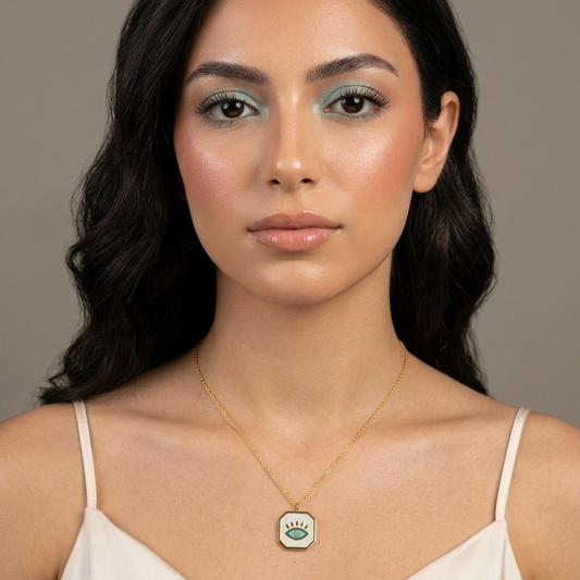 Woman wearing a necklace with a green pendant against a neutral background