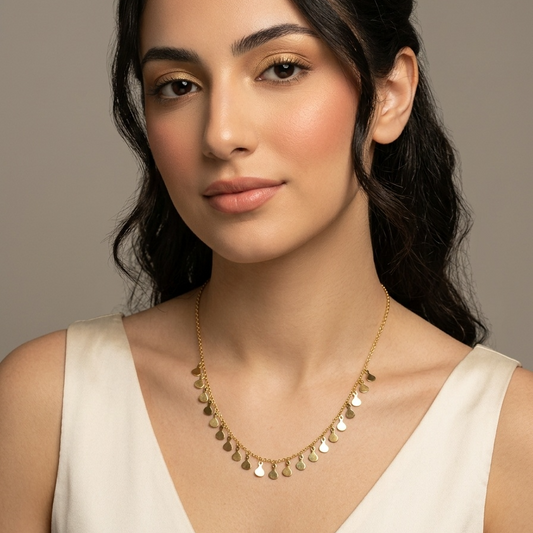Woman wearing a gold necklace against a neutral background