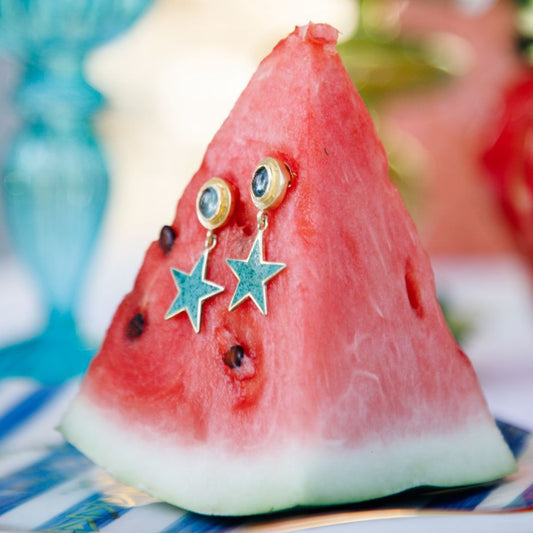 Sliced watermelon with decorative earrings on a blurred background