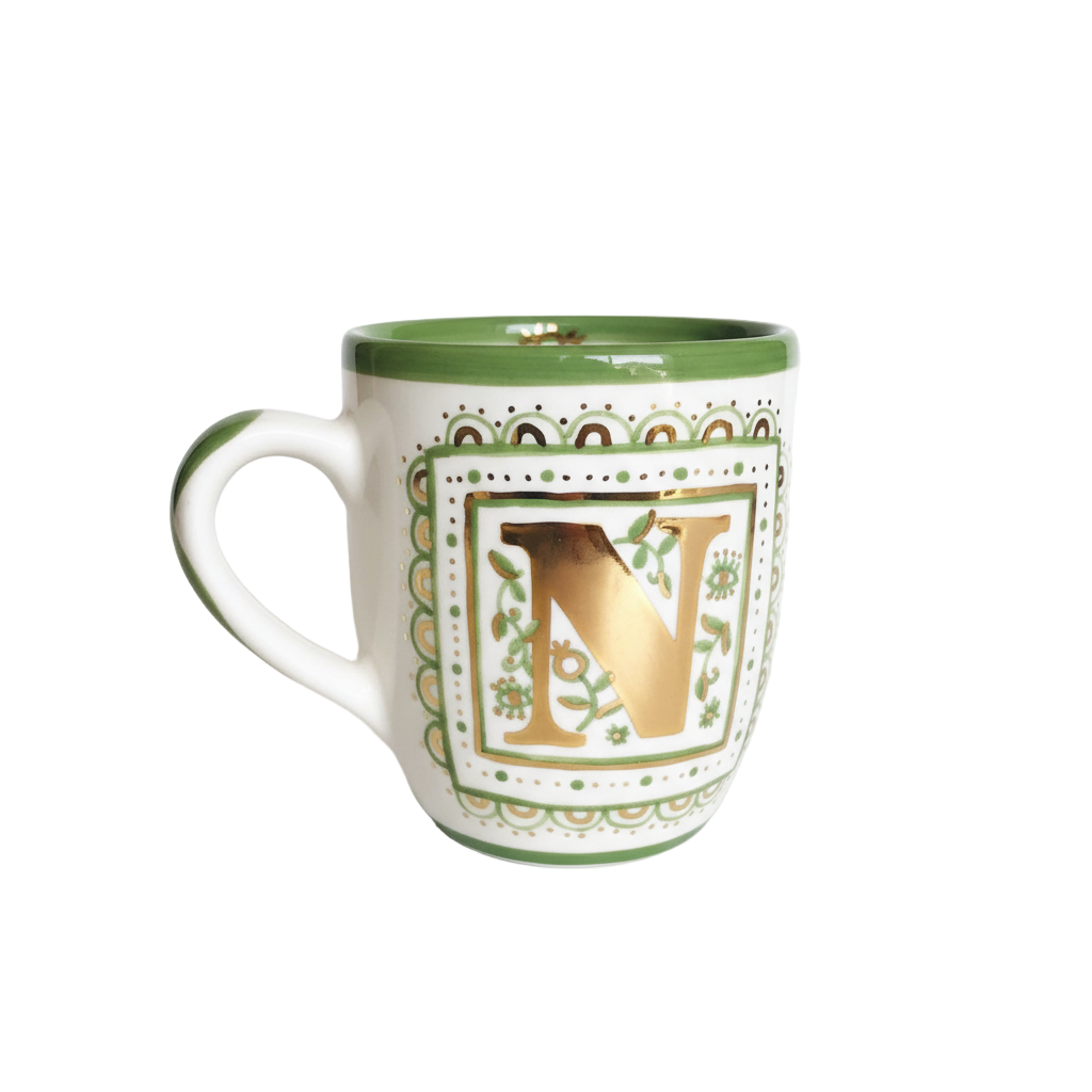Decorative mug with gold letter 'V' on a white background