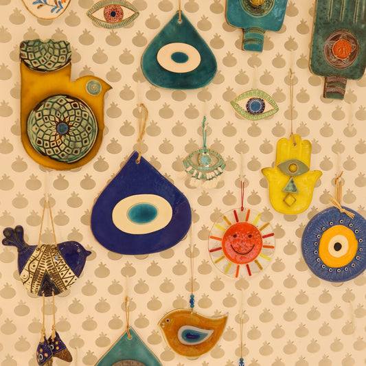 Collection of colorful ceramic fish and other shapes on a beige background