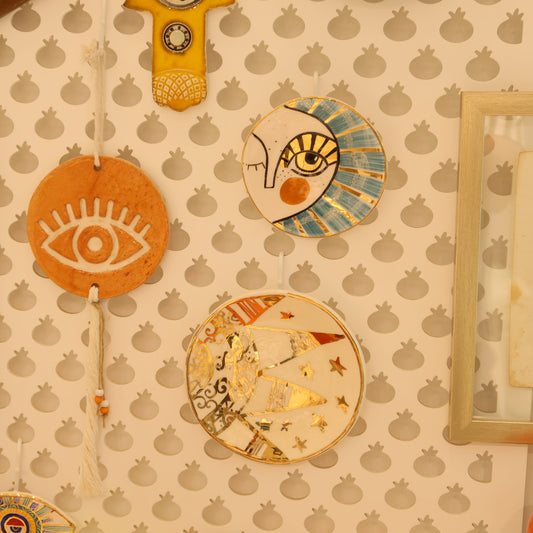 Decorative wall art with eye designs on a patterned wall.