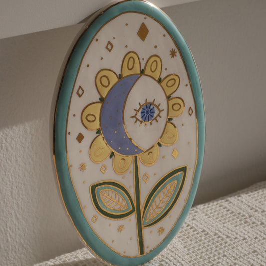 Decorative ceramic plate with floral design on a textured surface