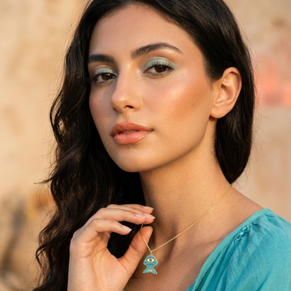 Woman wearing a turquoise top with a blurred natural background