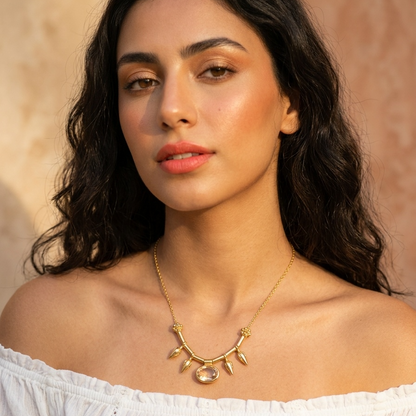 Woman wearing a gold necklace with a beige background