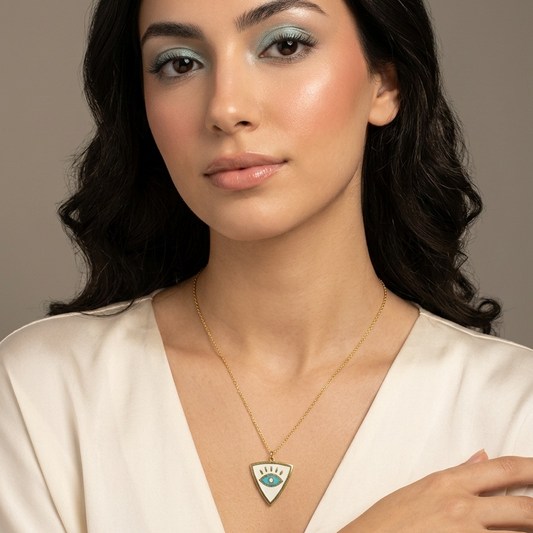 Woman wearing a necklace with a green pendant against a neutral background