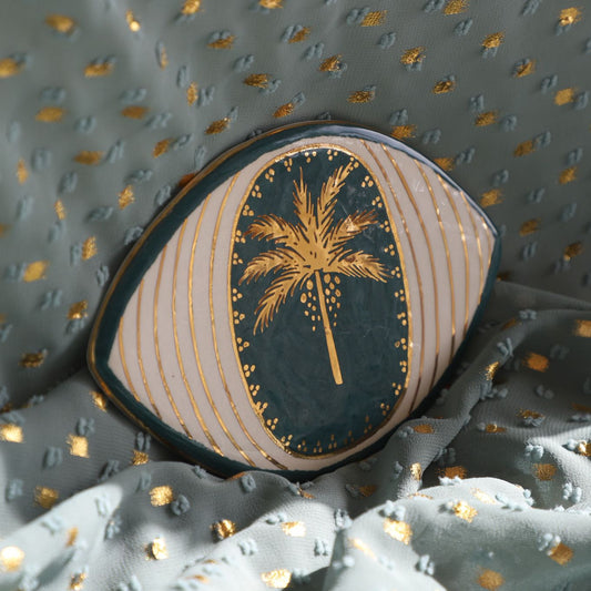 Decorative pillow with palm tree design on a textured fabric background