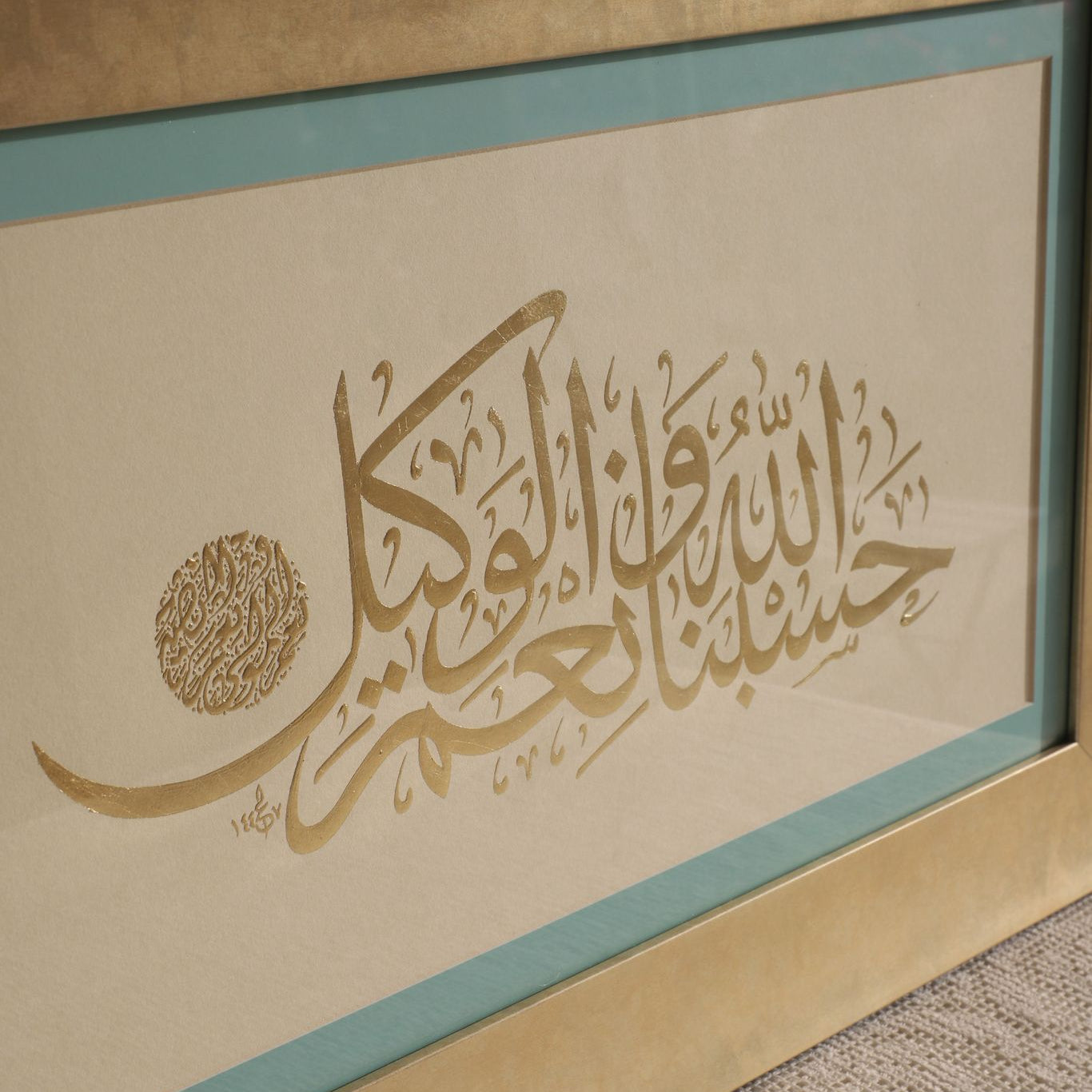 Framed Arabic calligraphy artwork on a textured surface