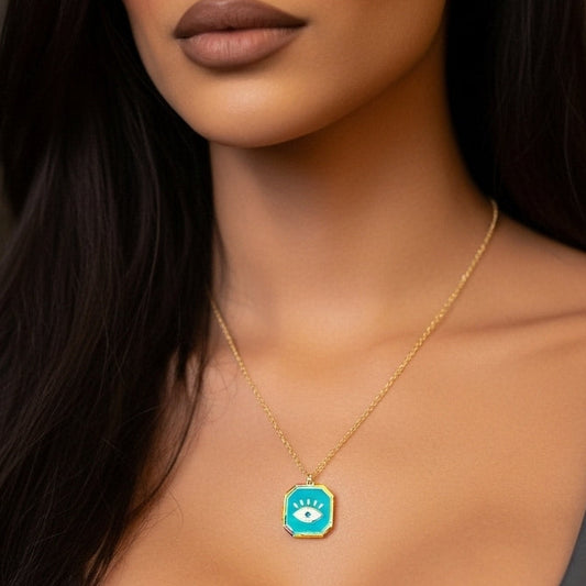Woman wearing a gold necklace with a green pendant against a blurred background